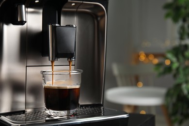 Espresso machine pouring coffee into glass against blurred background, closeup. Space for text