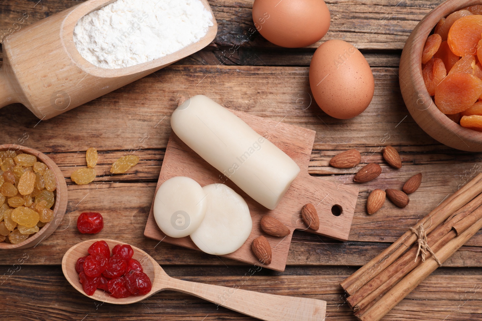 Photo of Marzipan and other ingredients for homemade Stollen on wooden table, flat lay. Baking traditional German Christmas bread