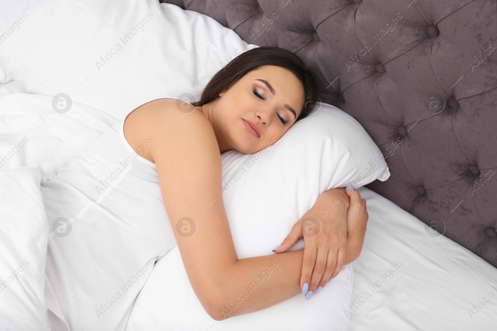 Photo of Beautiful woman sleeping on comfortable pillow in bed at home