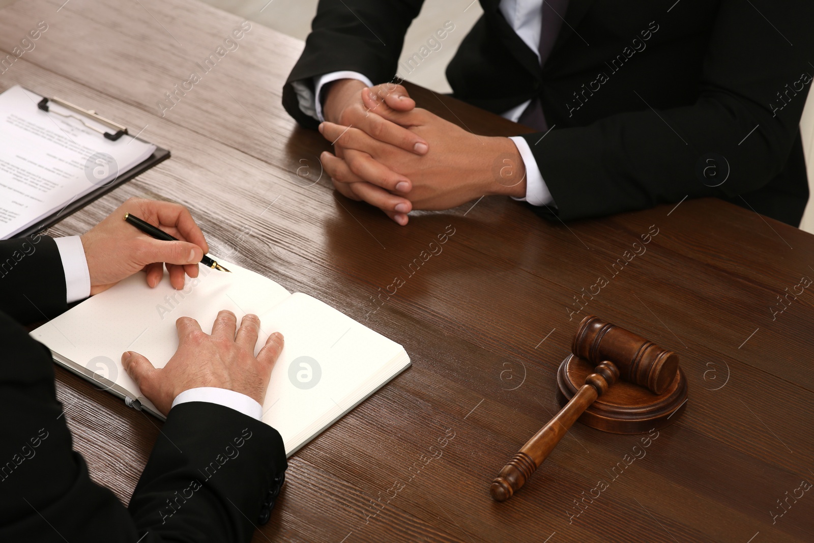 Photo of Law and justice. Lawyers working with documents at wooden table, closeup