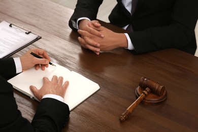 Law and justice. Lawyers working with documents at wooden table, closeup