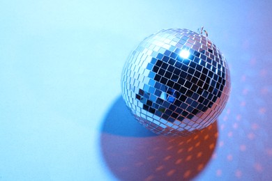 Photo of Bright shiny disco ball on color background. Space for text