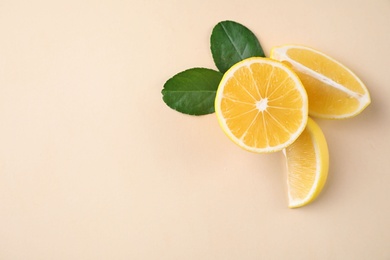 Photo of Fresh lemons and leaves on beige background, flat lay. Space for text