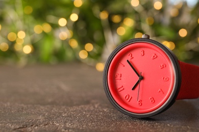 Photo of Stylish bright wrist watch on gray table, space for text. Fashion accessory