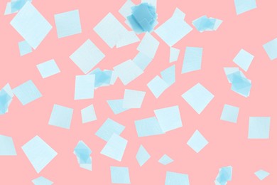 Image of Bright confetti falling on coral background. Party supply