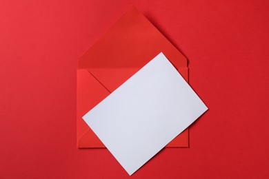 Photo of Letter envelope and card on red background, top view