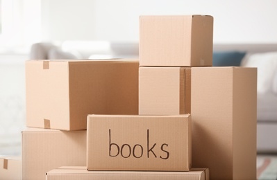 Photo of Pile of cardboard boxes indoors. Moving day