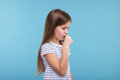 Photo of Sick girl coughing on light blue background