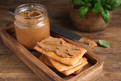 Photo of Crispy crackers with delicious meat pate on wooden table