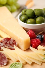 Snack set with delicious Parmesan cheese on wooden board, closeup