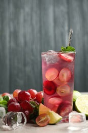 Photo of Soda water with grapes, ice and mint on table. Refreshing drink