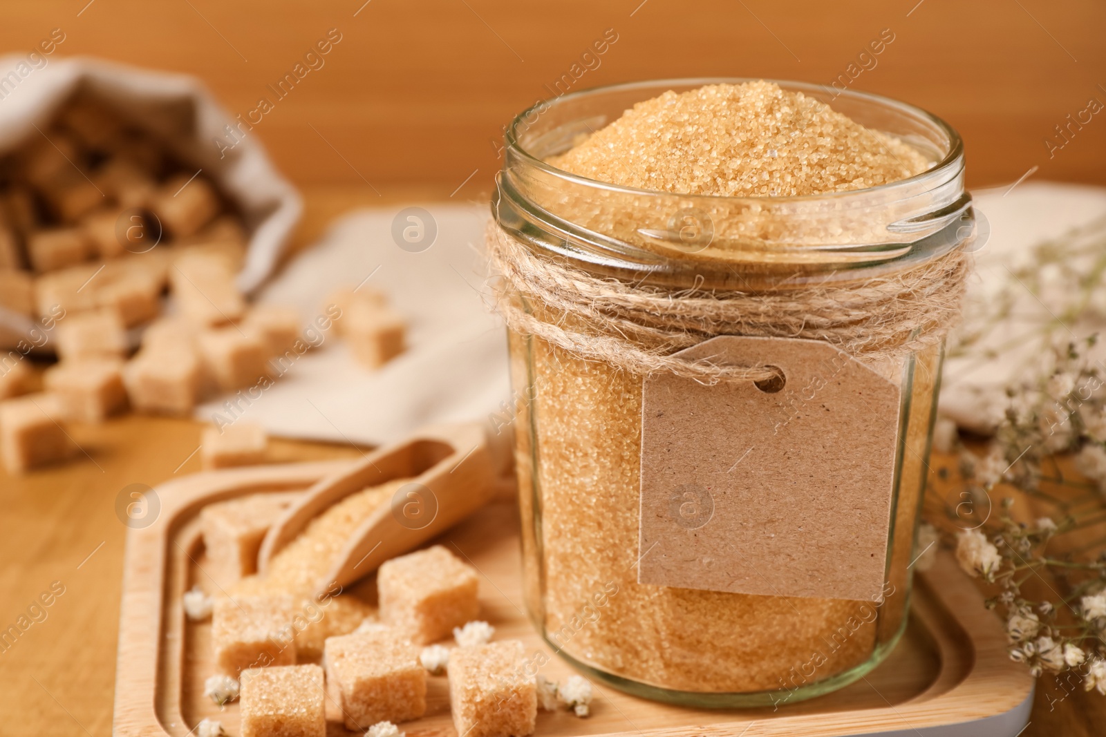 Photo of Jar with brown sugar on wooden table, closeup. Space for text