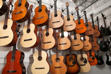 Photo of Rows of different guitars in music store, low angle view
