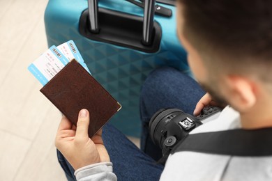 Photo of Man with suitcase, camera, passport and tickets, closeup