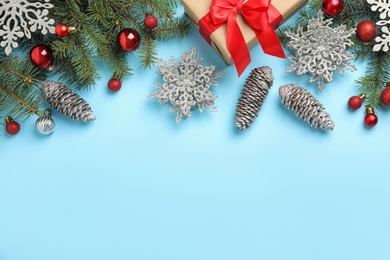 Photo of Fir branches with Christmas decoration on light blue background, flat lay. Space for text