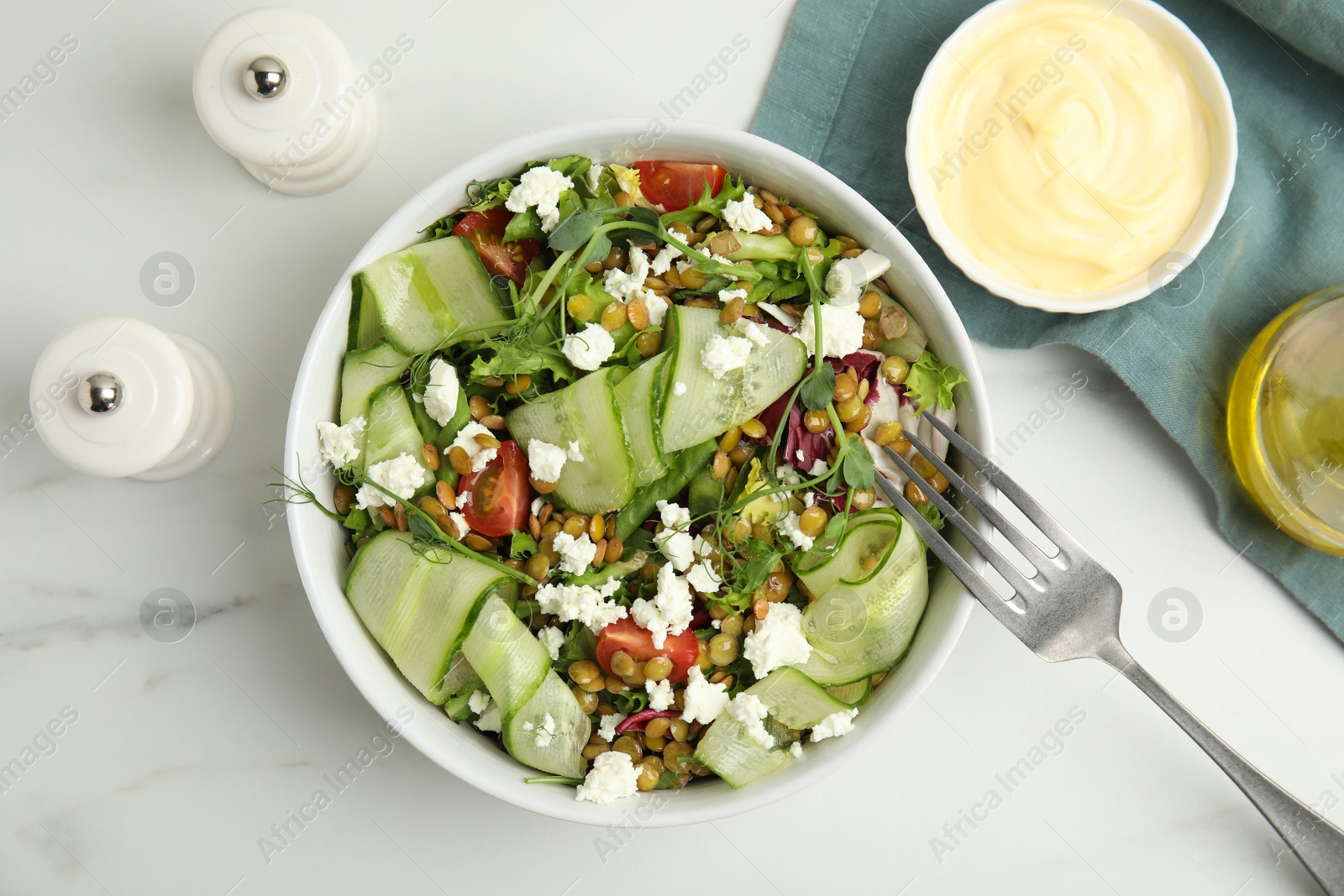 Photo of Delicious salad with lentils, vegetables and feta cheese served on white table, flat lay