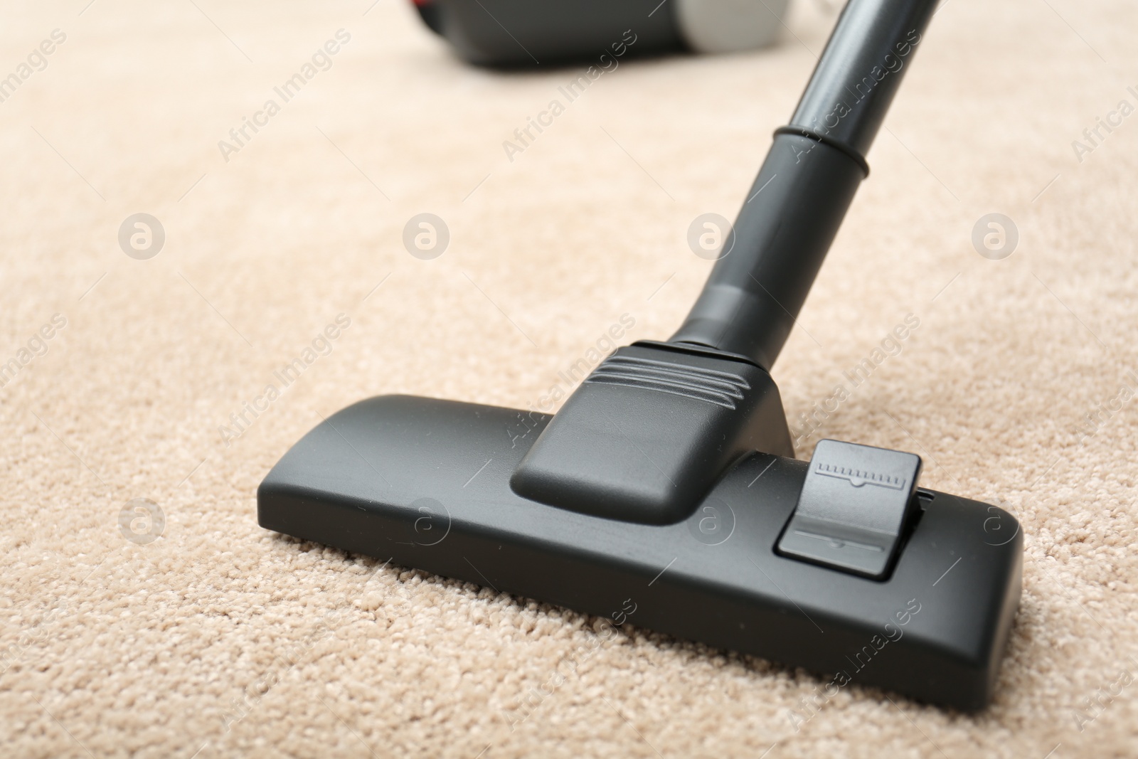 Photo of Removing dirt from carpet with modern vacuum cleaner indoors, closeup