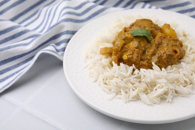 Photo of Delicious chicken curry with rice on white tiled table, closeup