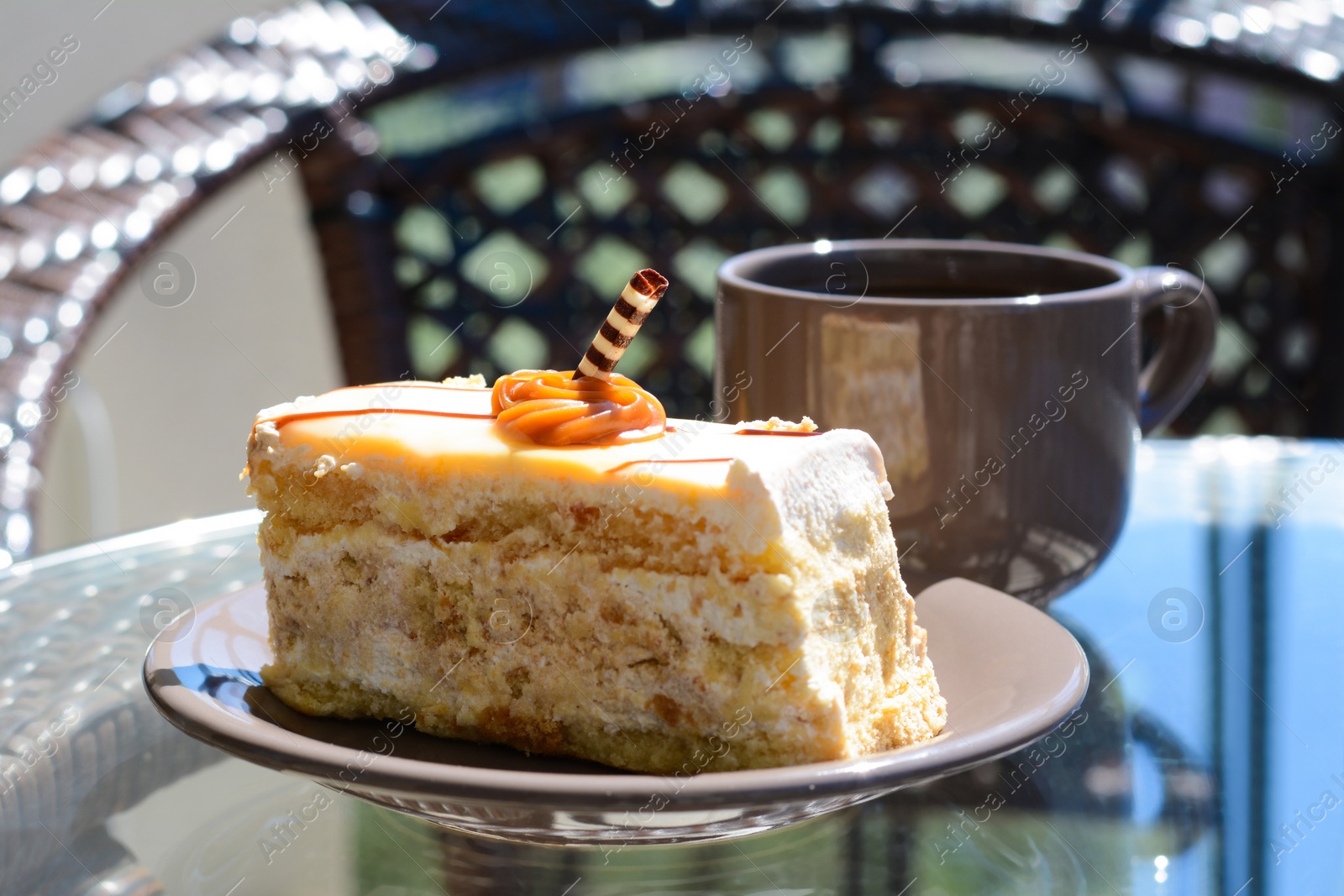 Photo of Tasty dessert and cup of fresh aromatic coffee on glass table outdoors, closeup