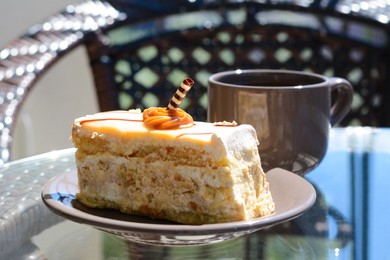 Tasty dessert and cup of fresh aromatic coffee on glass table outdoors, closeup