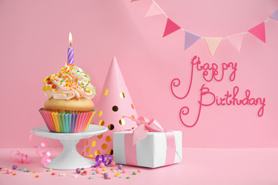 Image of Composition with delicious cupcake on pink background. Happy Birthday