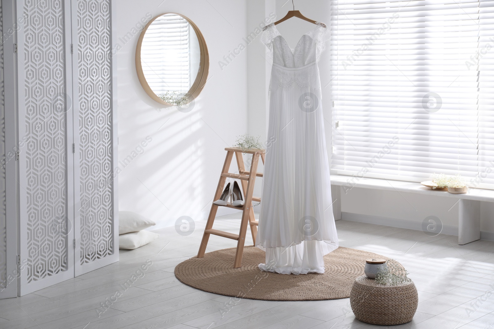 Photo of Beautiful wedding dress, shoes and flowers in room