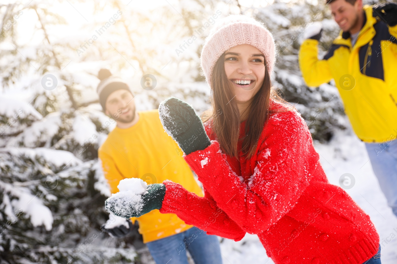 Photo of Happy friends playing snowballs outdoors. Winter vacation