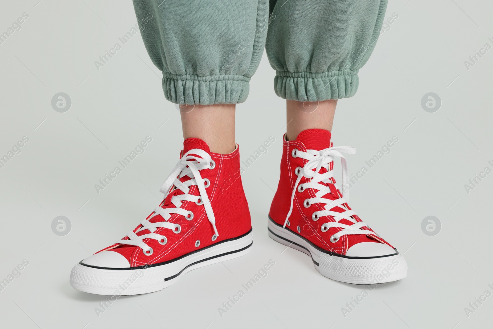 Photo of Woman in stylish gumshoes on white background, closeup