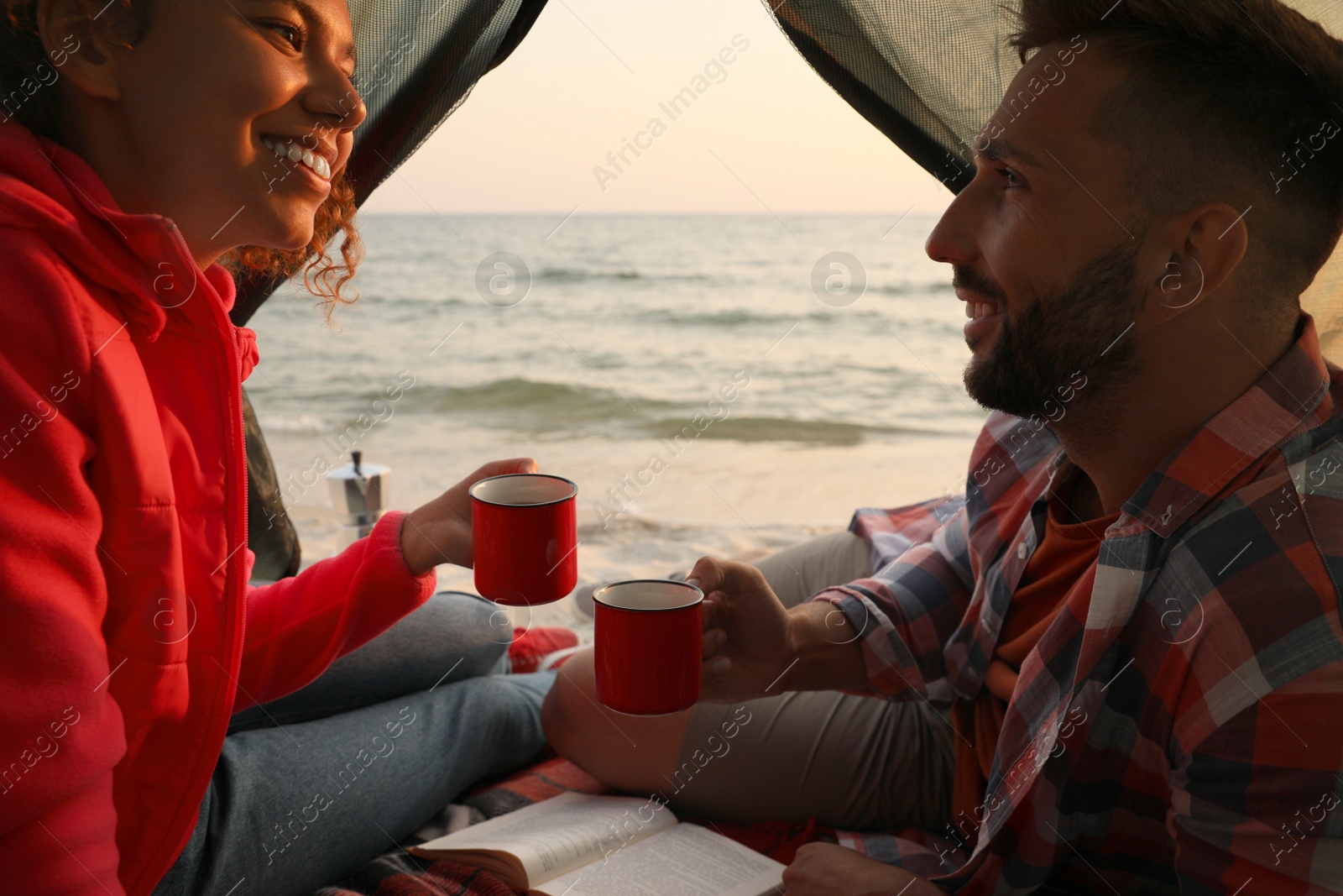 Photo of Couple resting in camping tent near sea