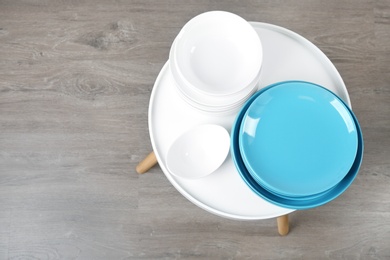 Photo of Different clean tableware on small table in kitchen, top view