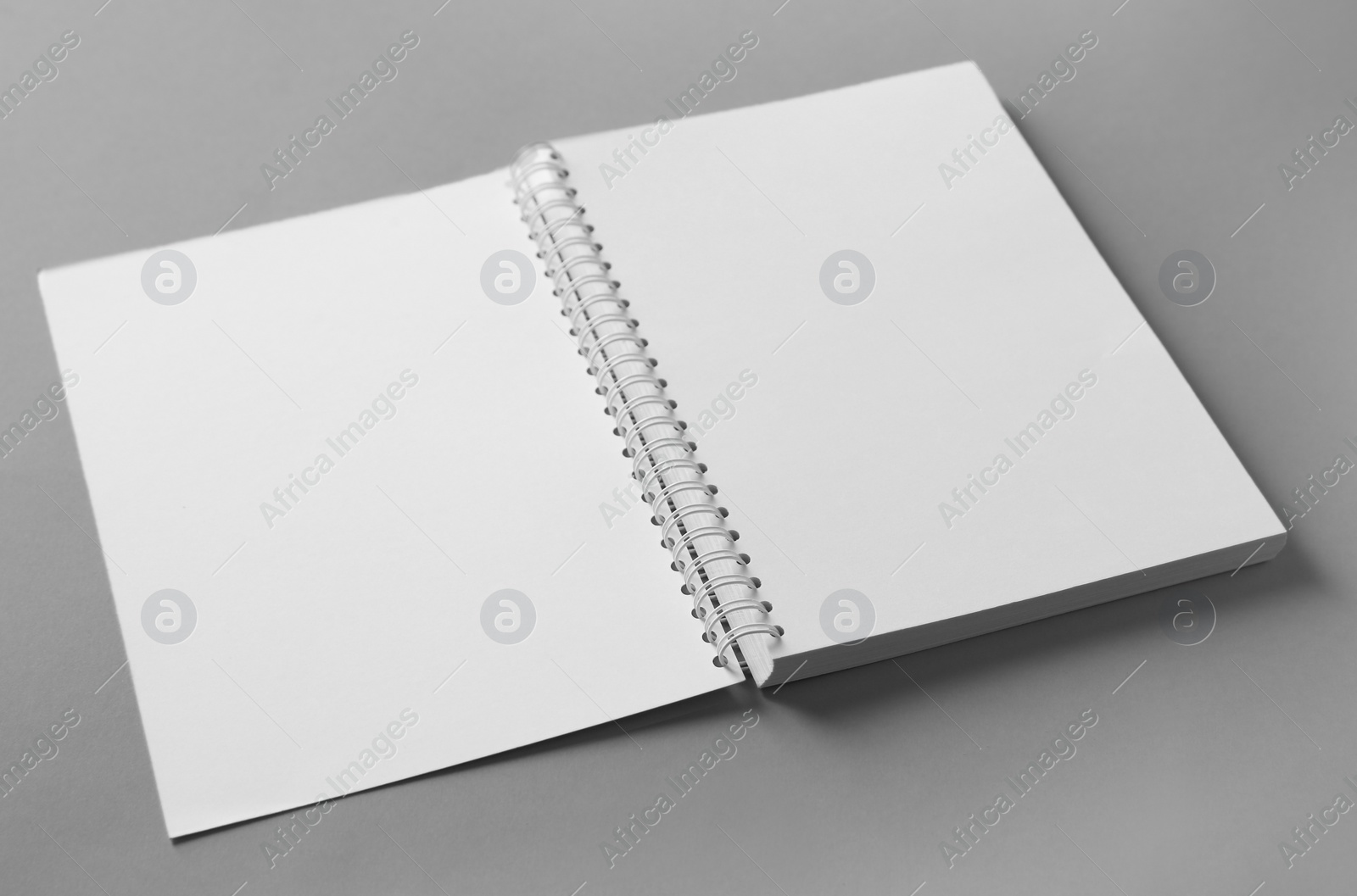 Photo of Open blank notebook on grey background. Mockup for design