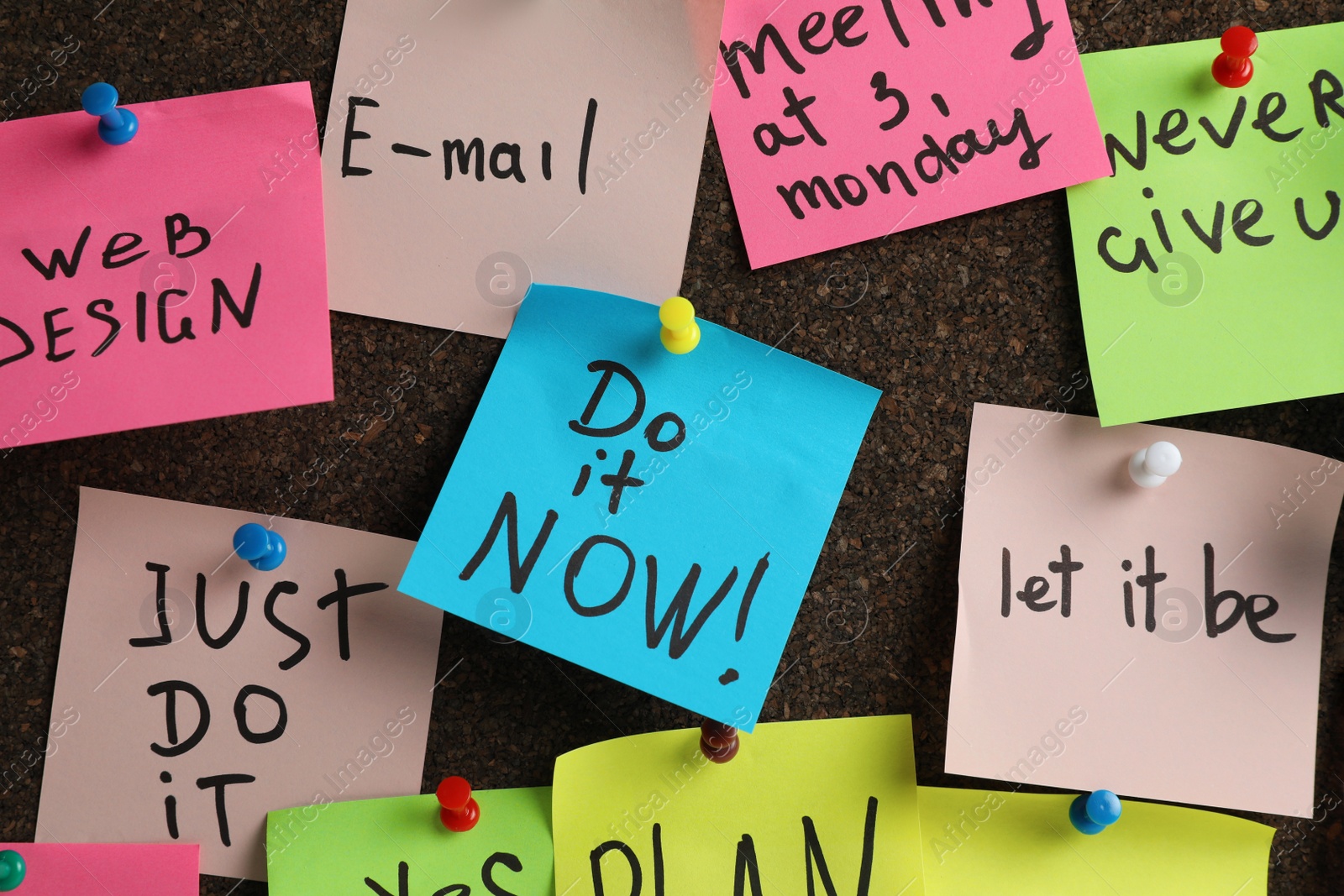 Photo of Colorful reminder notes pinned to cork board