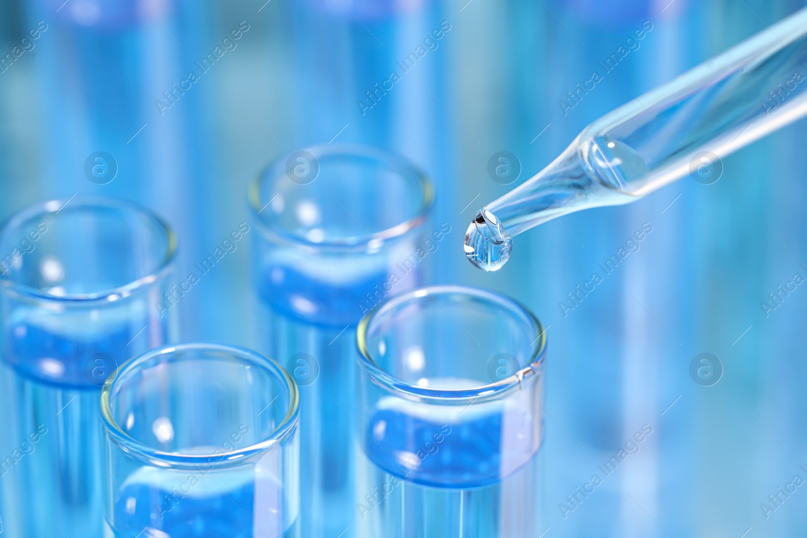 Photo of Dripping reagent into test tube on blurred background, closeup and space for text. Laboratory analysis