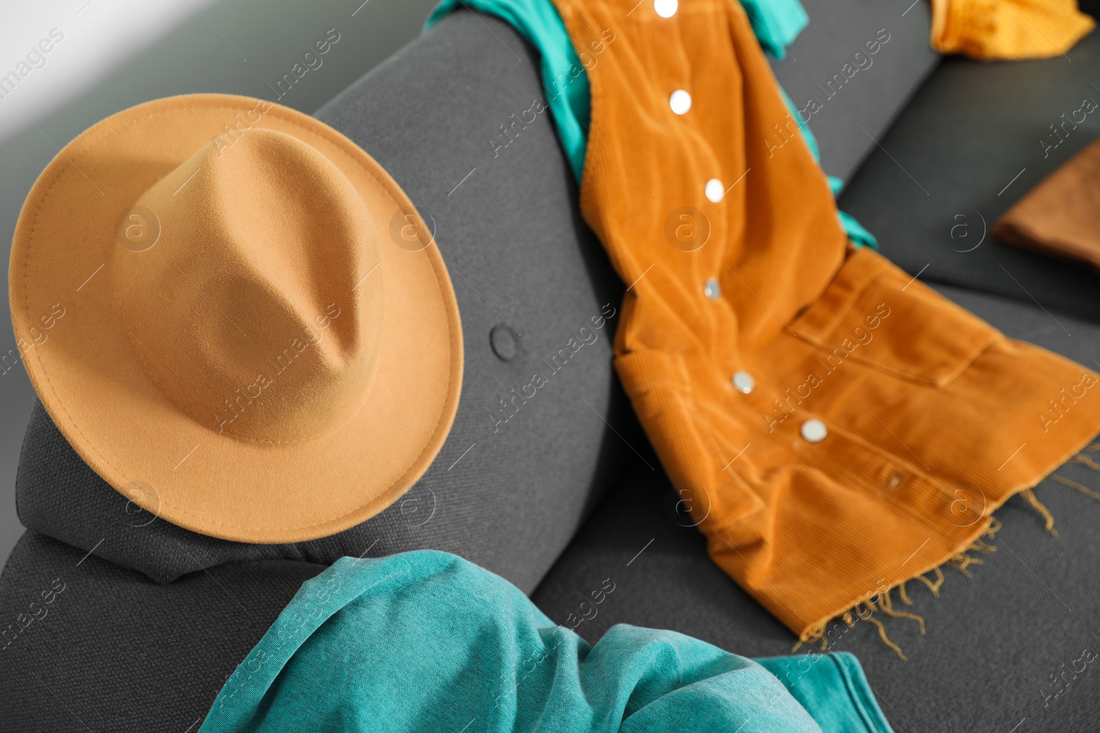 Photo of Messy pile of clothes on sofa in living room, closeup