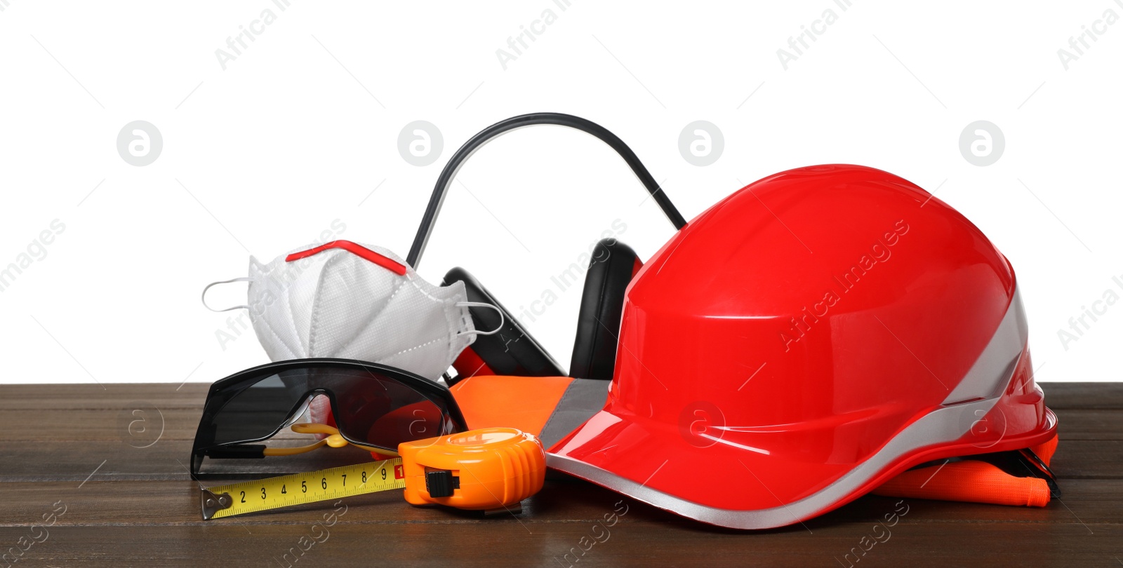 Photo of Set with safety equipment and tools on wooden table against white background