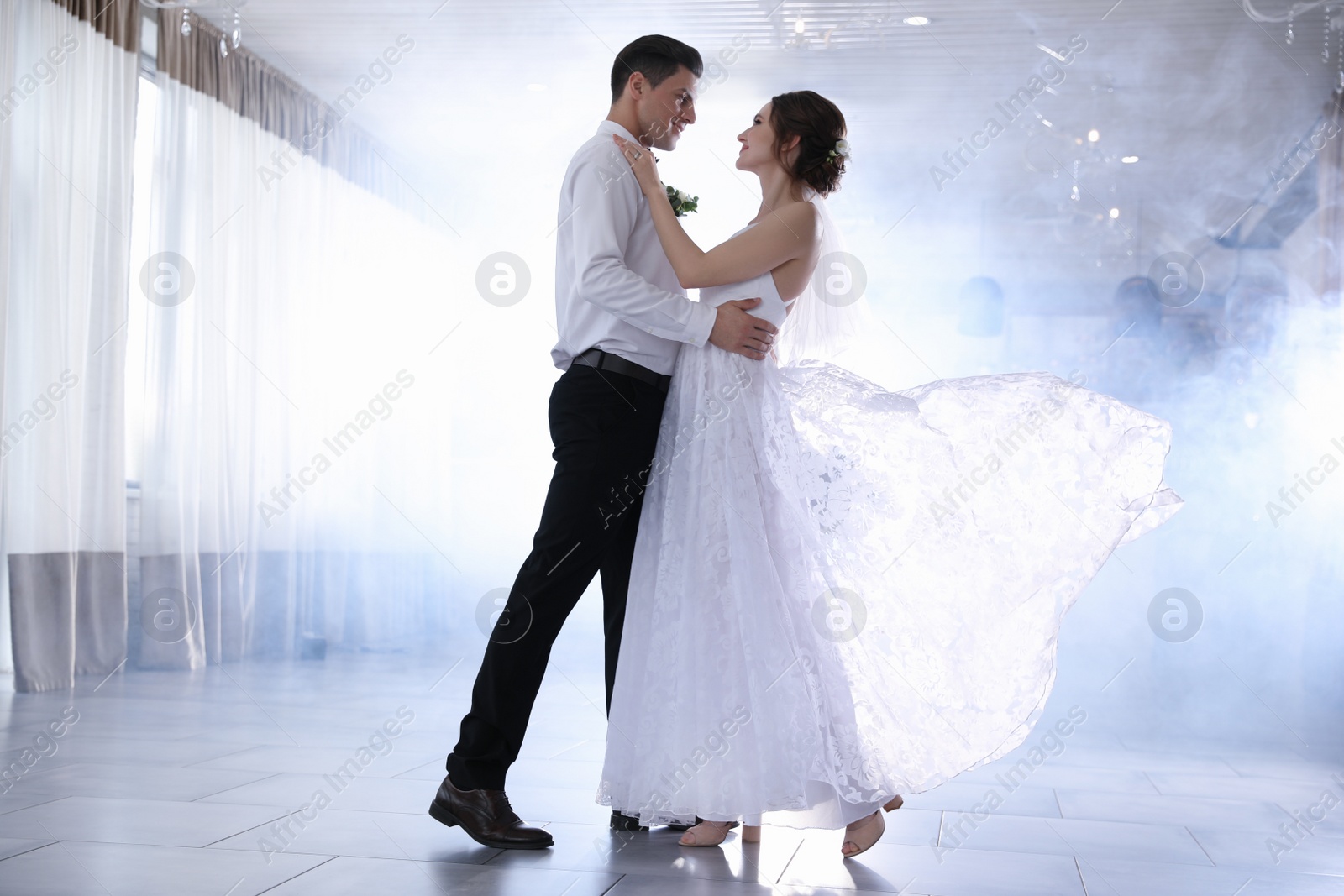 Photo of Happy newlywed couple dancing together in festive hall