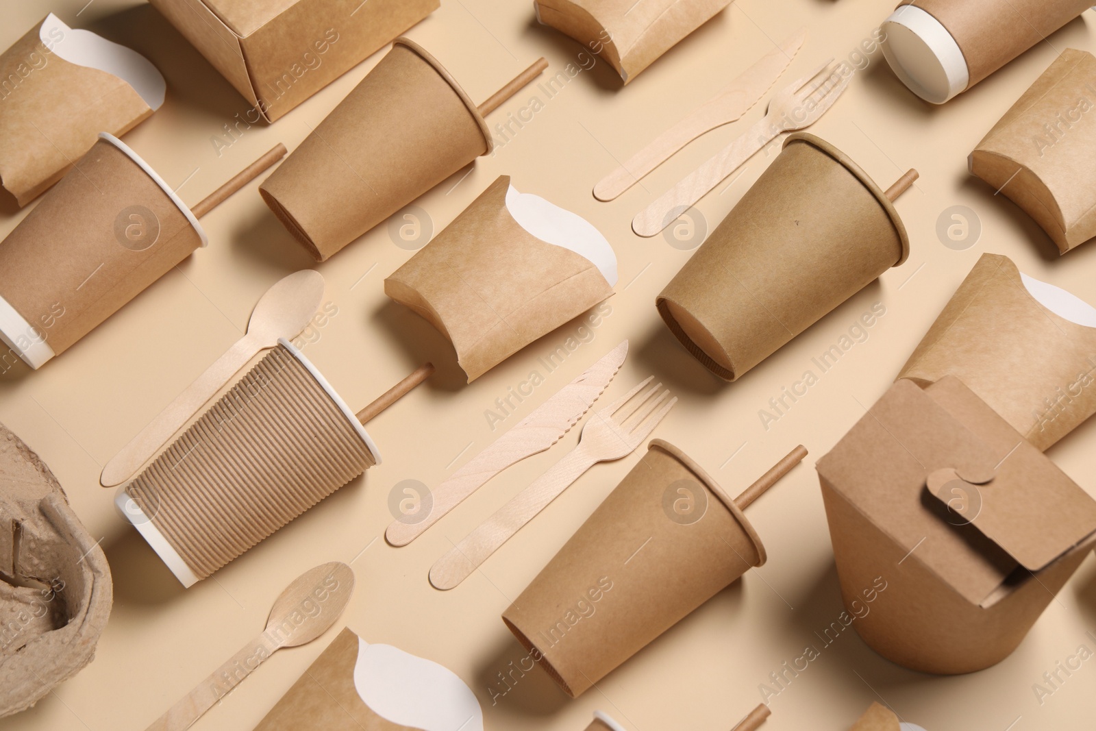 Photo of Eco friendly food packaging. Paper containers and wooden cutlery on beige background