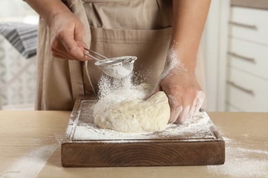 Photo of Female baker preparing bread dough at table, closeup