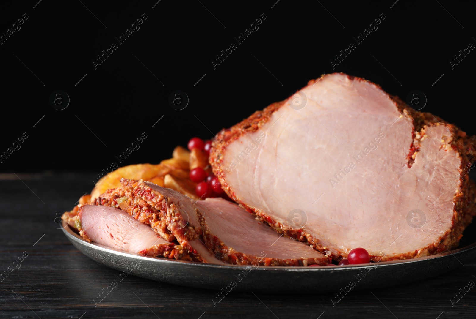 Photo of Plate with delicious ham on grey wooden table against black background