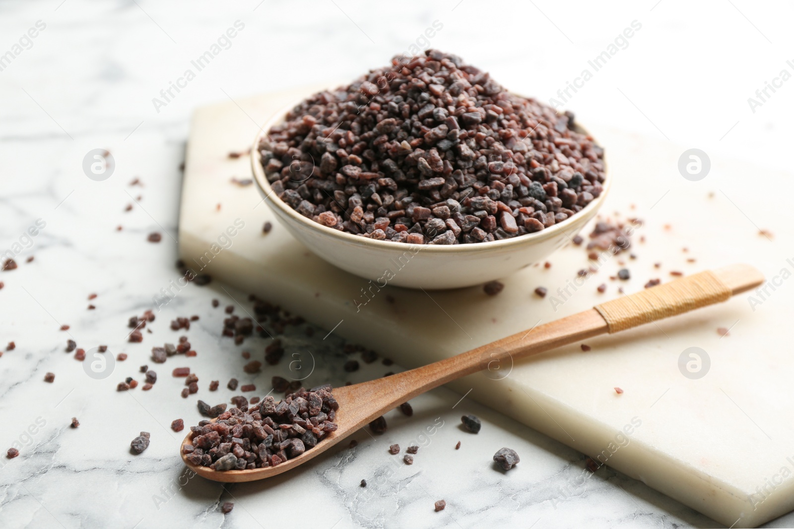 Photo of Natural black salt on white marble table