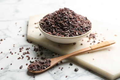 Photo of Natural black salt on white marble table