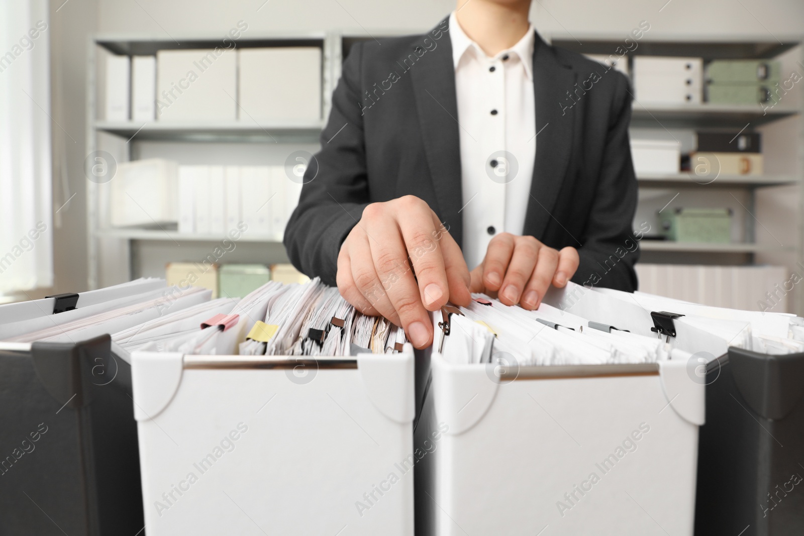 Photo of Woman taking documents from folder in archive, closeup