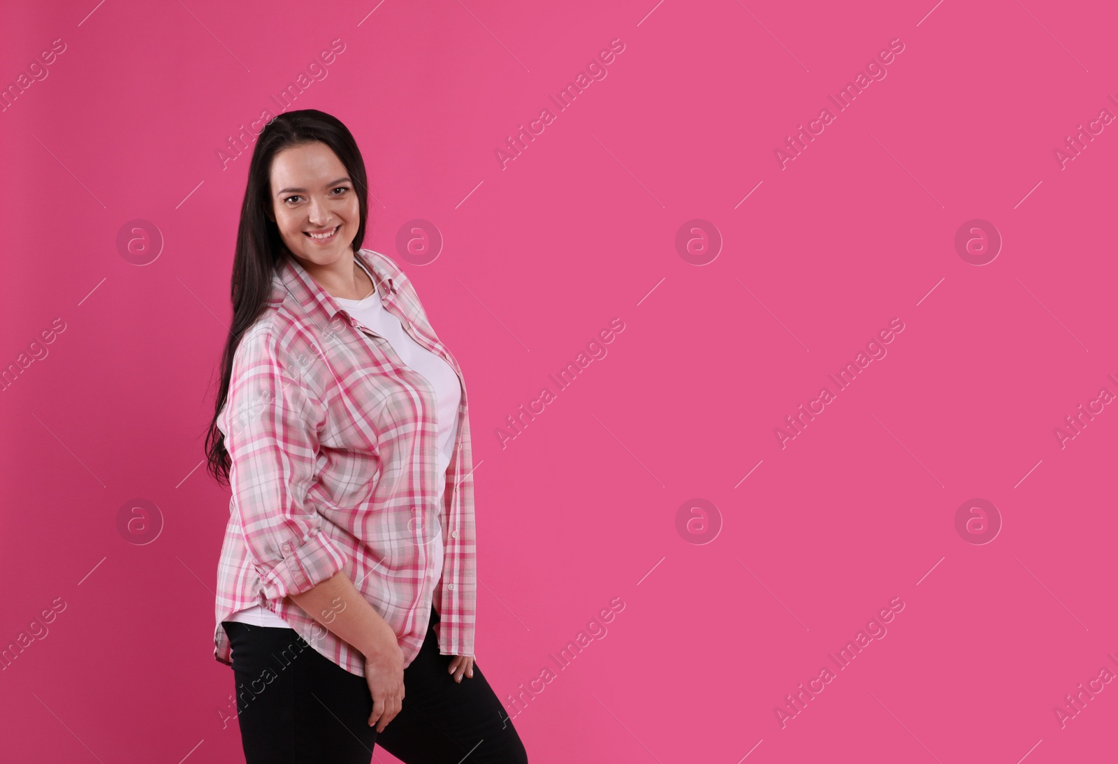 Photo of Beautiful overweight woman with charming smile on pink background. Space for text