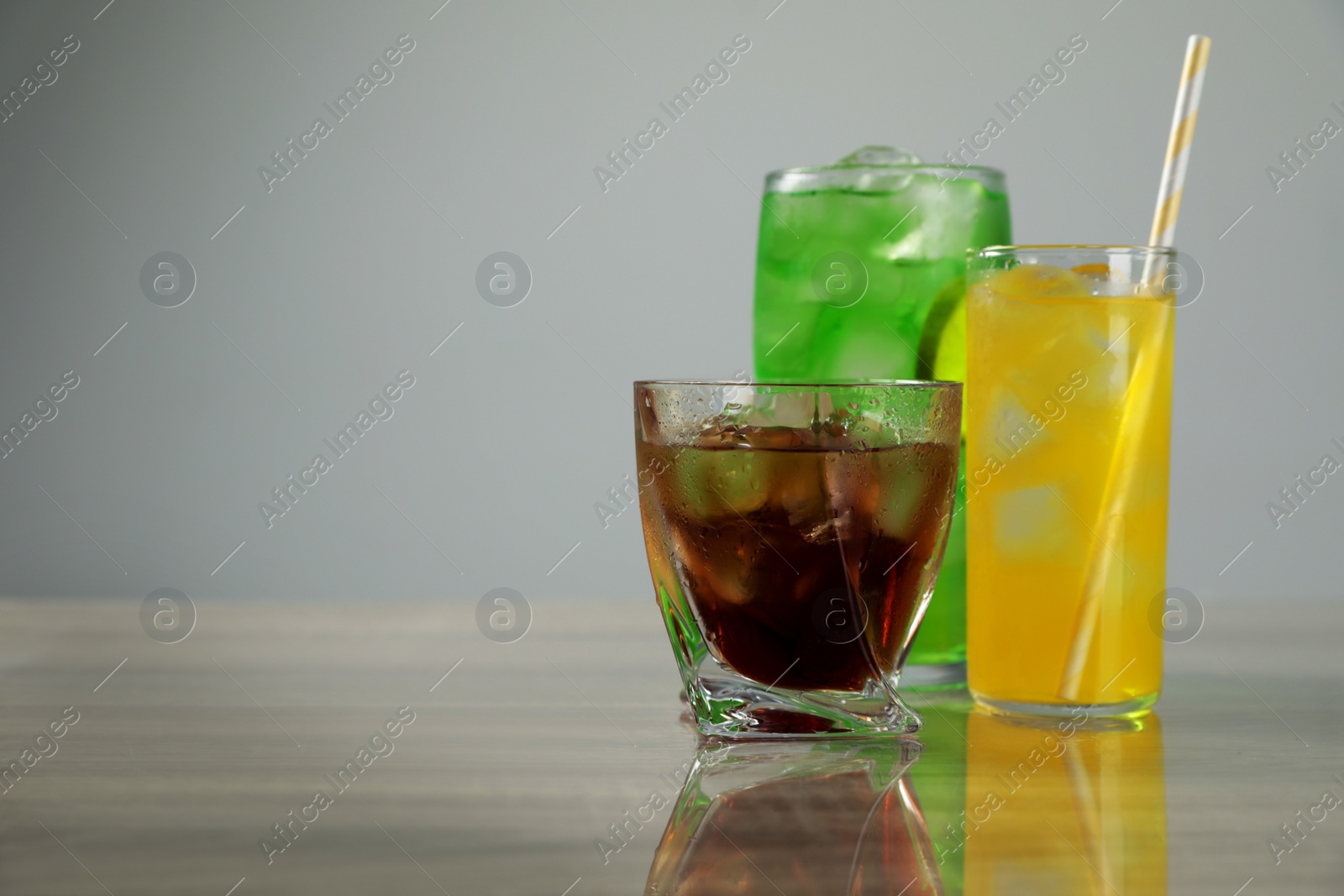 Photo of Delicious refreshing drinks on grey table. Space for text