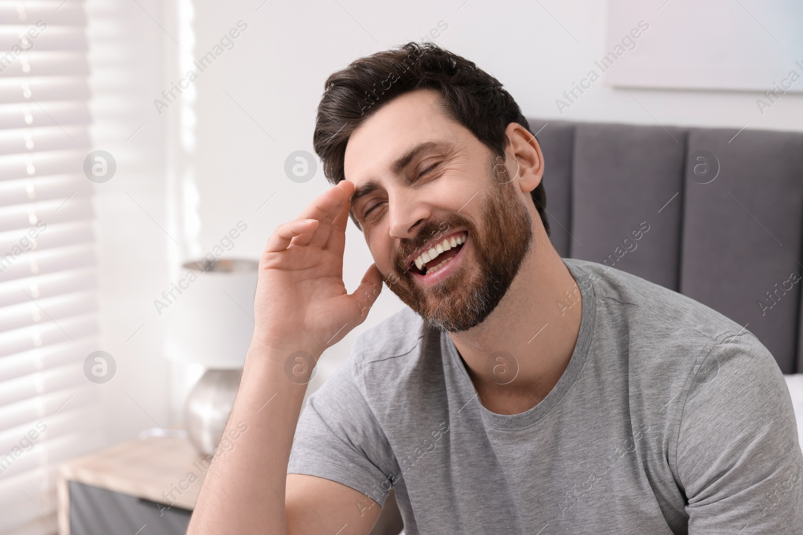 Photo of Portrait of handsome man laughing at home