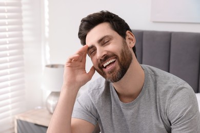 Portrait of handsome man laughing at home