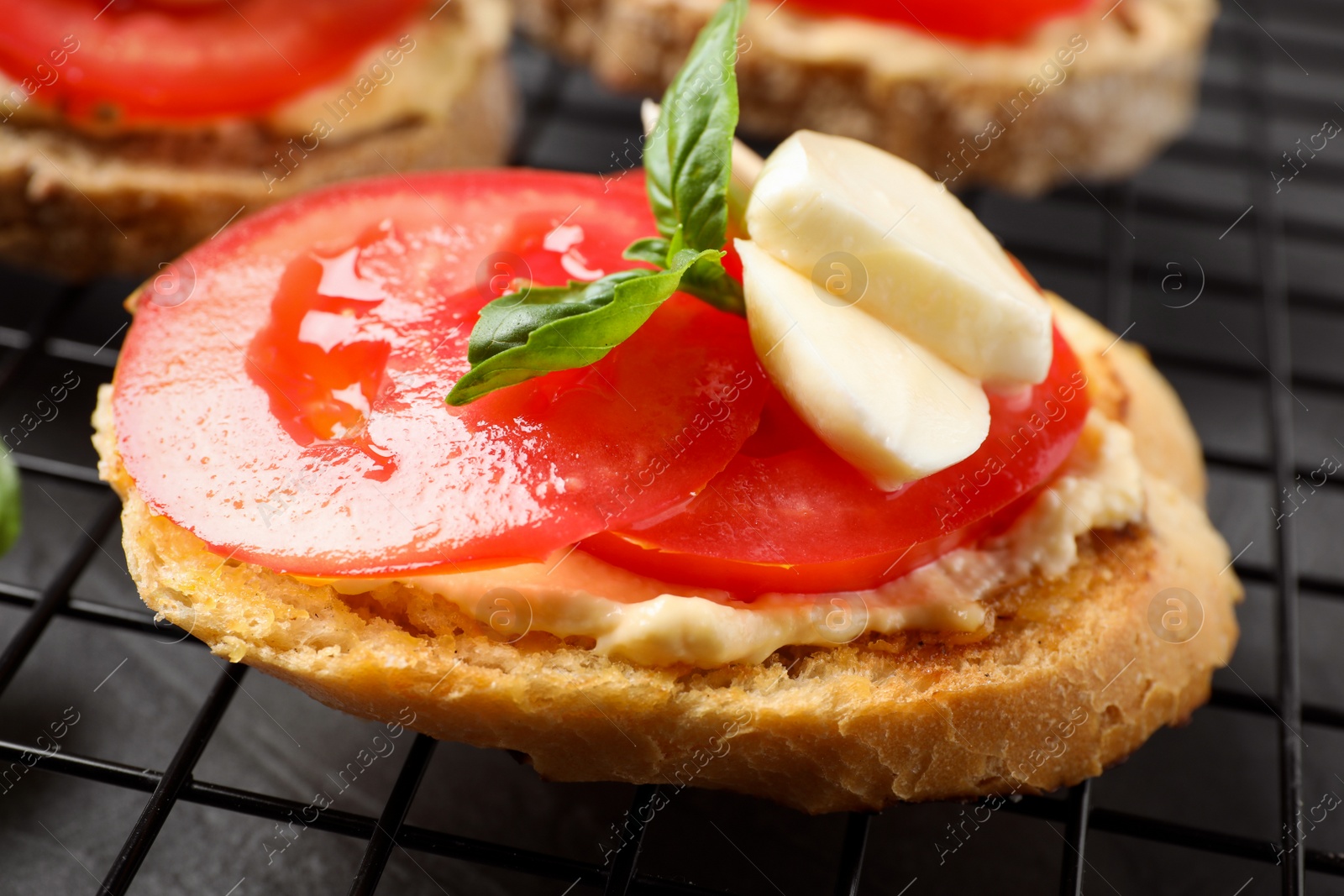 Photo of Tasty fresh tomato bruschettas on cooling rack