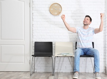 Photo of Young man being happy after success job interview, indoors