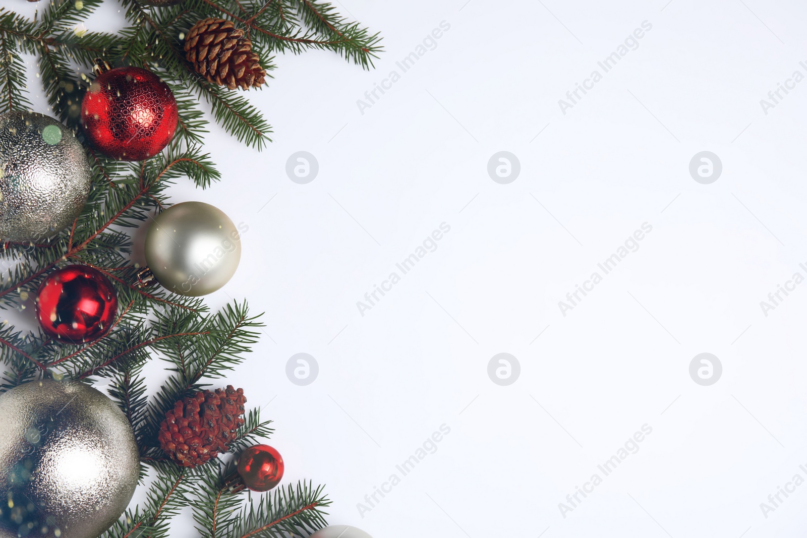 Photo of Christmas greeting card with space for text. Flat lay composition of fir tree branches and festive decor on white background