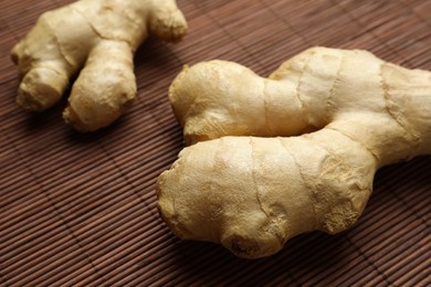 Fresh aromatic ginger on bamboo mat, closeup